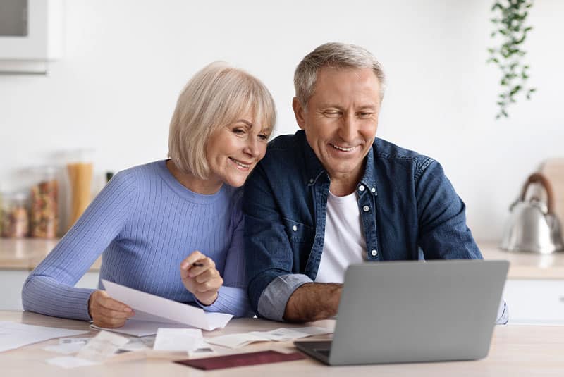 older couple dental financing on computer at home